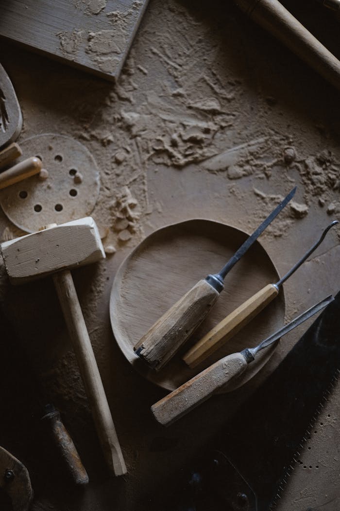Home A collection of traditional woodworking tools on a dusty workbench in a workshop.